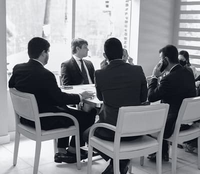 Sócios do escritório reunidos em torno de uma mesa discutindo um caso